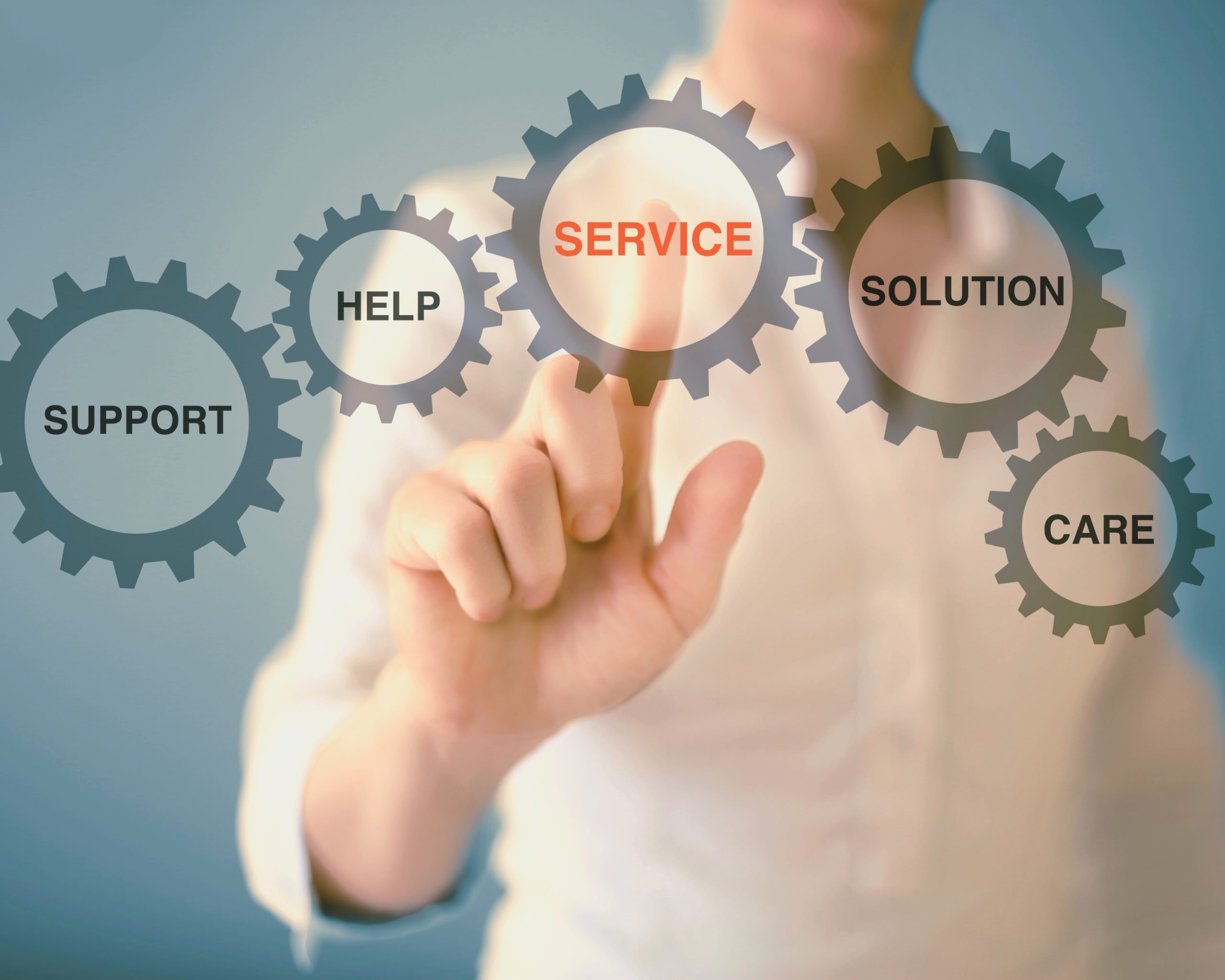 @Aydinynr_Getty - Personne interagissant avec des engrenages virtuels affichant les mots « Service », « Support », « Help », « Solution » et « Care ».