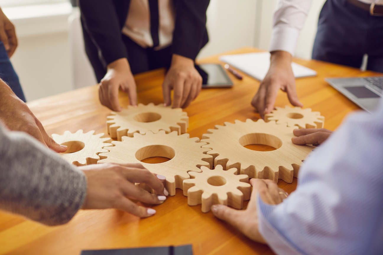 Plusieurs collaborateurs qui imbriquent des objets entre eux afin de faire un travail d'équipe